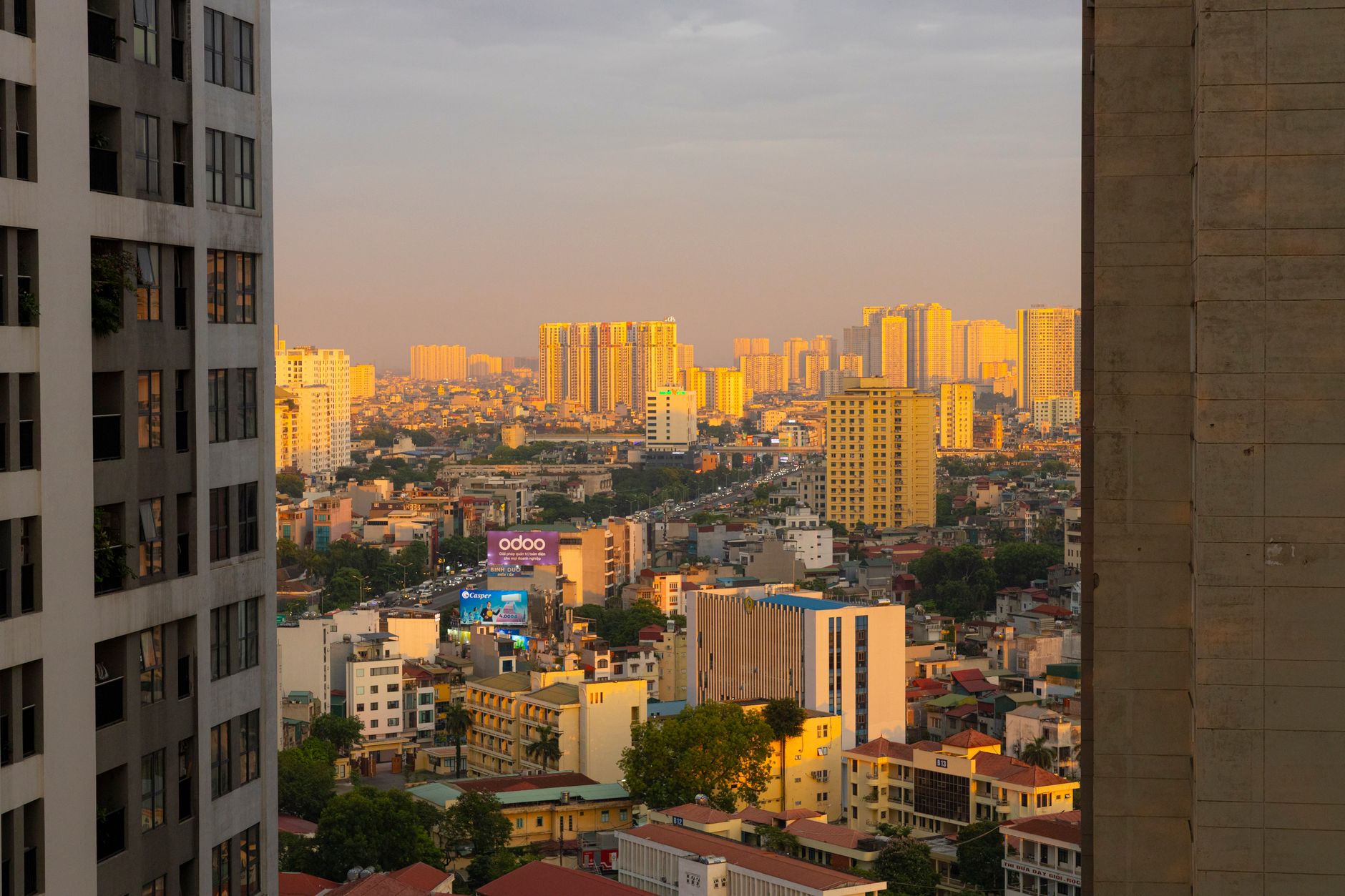 Stunning sunset over Hanoi cityscape with golden light reflecting on buildings, creating a warm urban atmosphere.
