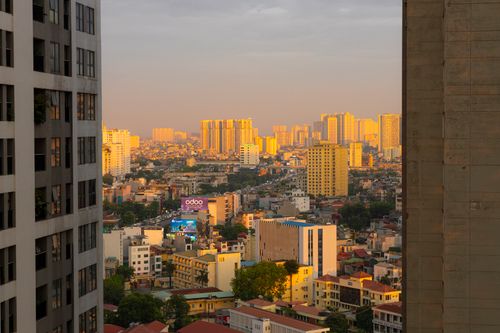 Free Stunning sunset over Hanoi cityscape with golden light reflecting on buildings, creating a warm urban atmosphere. Stock Photo