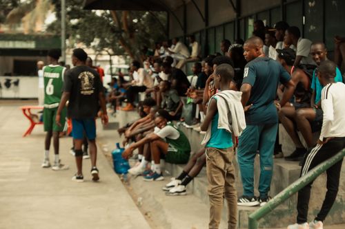 Free Crowd gathered at an outdoor basketball game, observing players on the court. Stock Photo