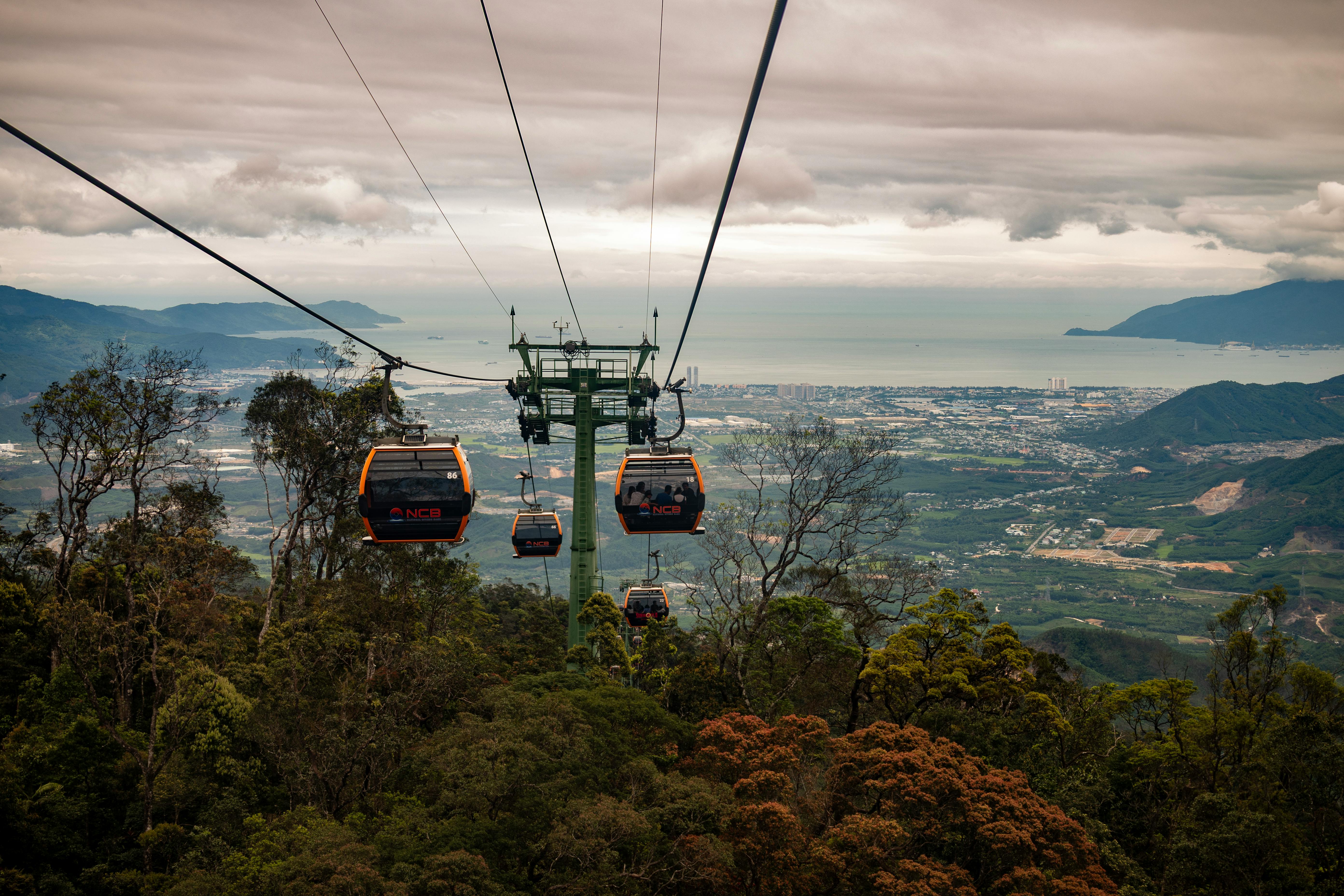 Aerial view of cable cars soaring over the lush landscape of Bana Khurd, offering a stunning vista.