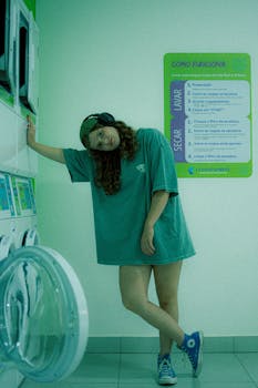 Relaxed young woman with headphones leaning in a laundromat in Sete Lagoas, Brazil.
