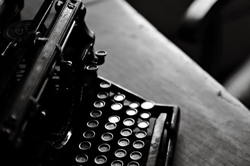 Free Black and white image of a classic typewriter on a wooden desk, evoking nostalgia. Stock Photo