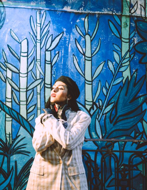 Free A fashionable woman poses confidently against a colorful mural in Buenos Aires, Argentina. Stock Photo