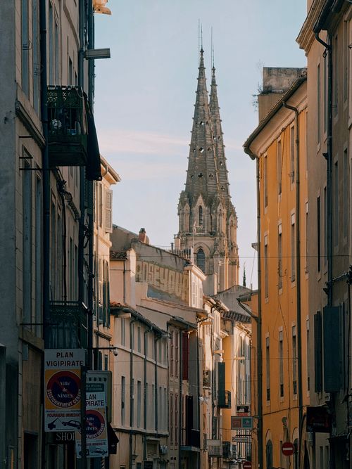 Free Historic European street view with a towering church spire under a clear sky. Stock Photo