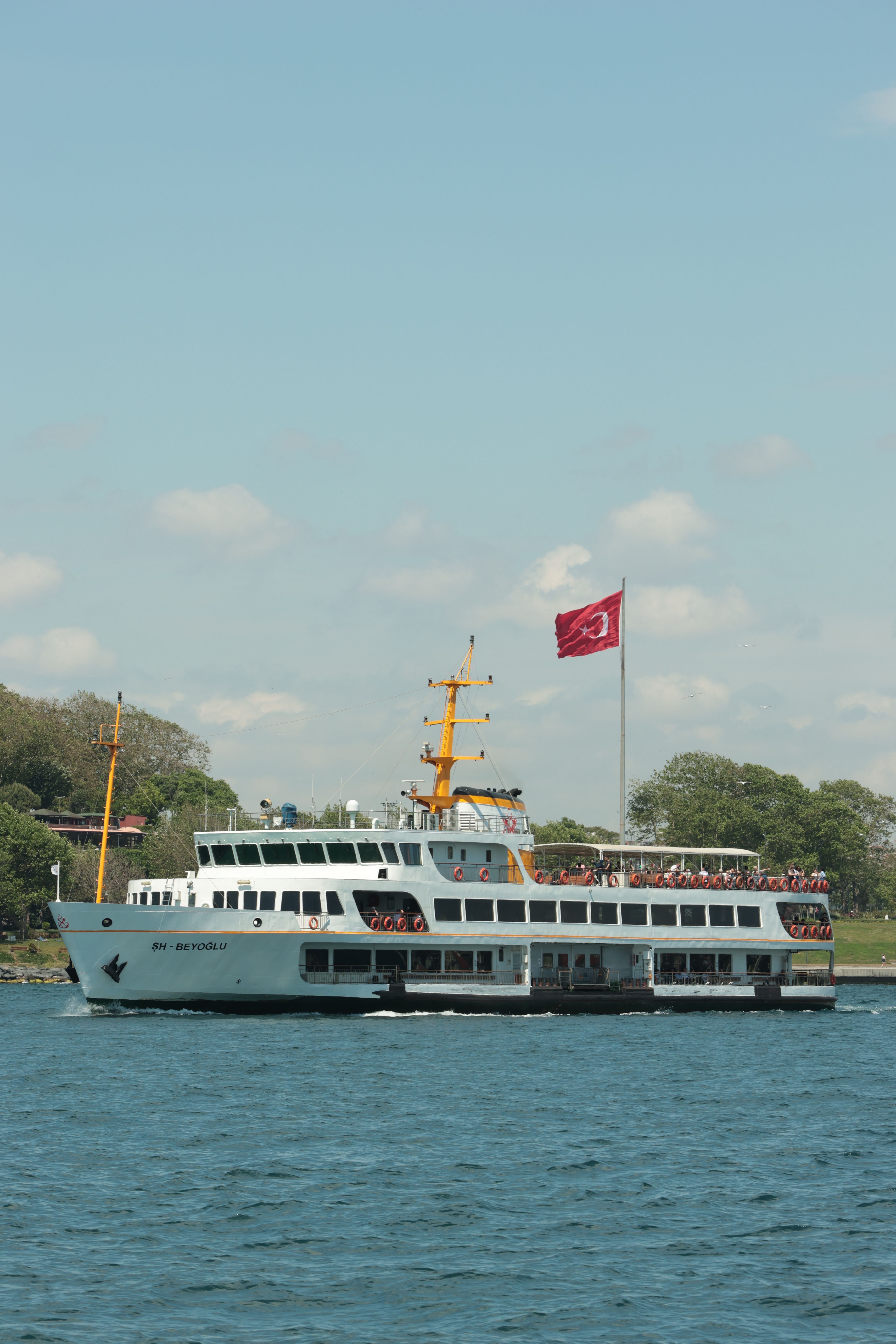 Ferry sailing on a clear day with Turkish flag, perfect for travel and tourism concepts.