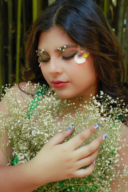 Free Enchanting portrait of a woman adorned with floral makeup, surrounded by delicate baby's breath blooms. Stock Photo