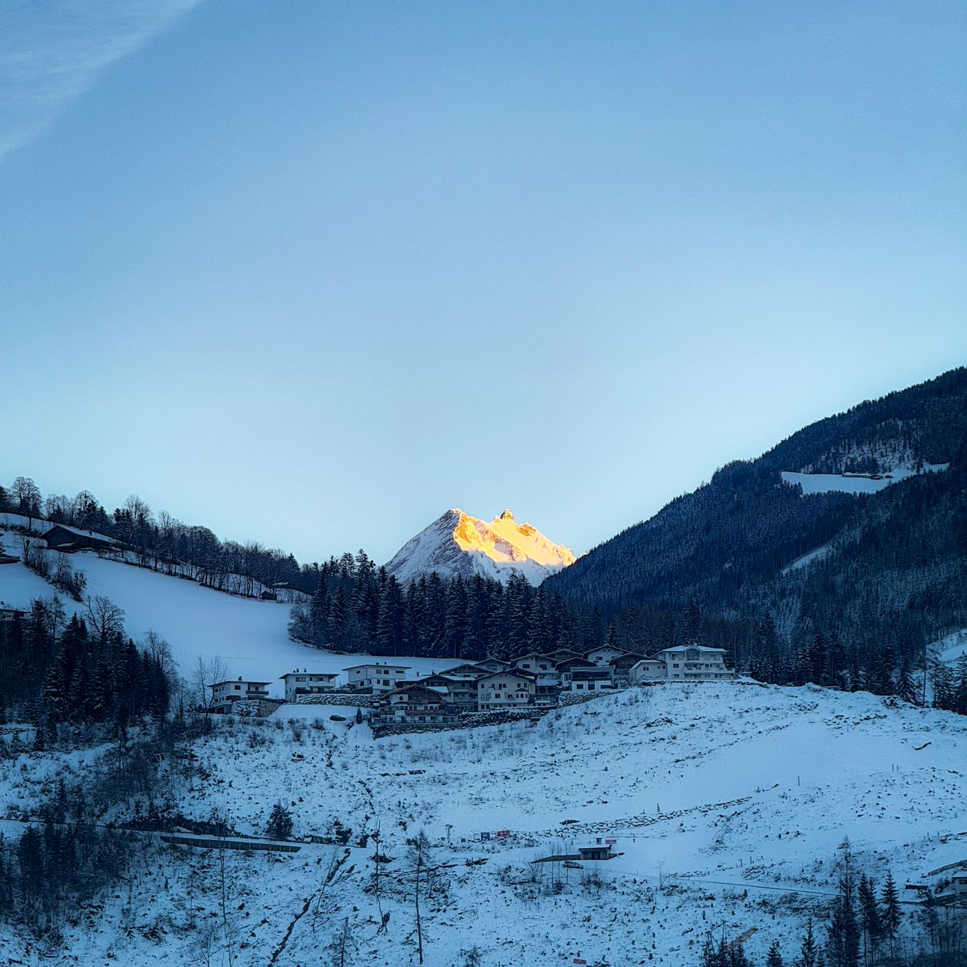 Snow-covered peaks and a village at sunset in Tyrol, Austria