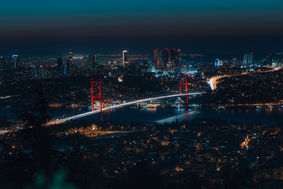 Capture the breathtaking night view of Istanbul's skyline and the illuminated Bosphorus Bridge, showcasing vibrant city lights.