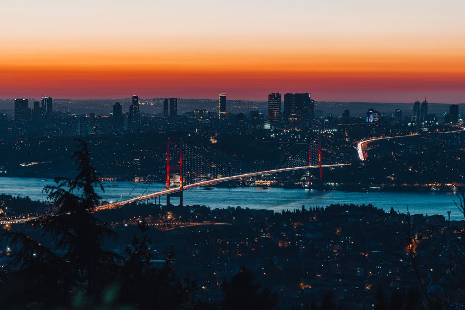 Panoramic view of Istanbul's cityscape with Bosphorus Bridge at sunset, highlighting the vibrant skyline.