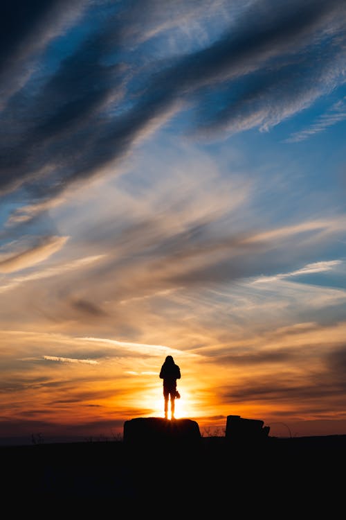 Free Silhouette Of A Person Standing On A Rock Stock Photo