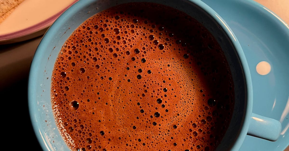 Blue cup of frothy coffee with crackers on a plate. Warm and cozy setting.