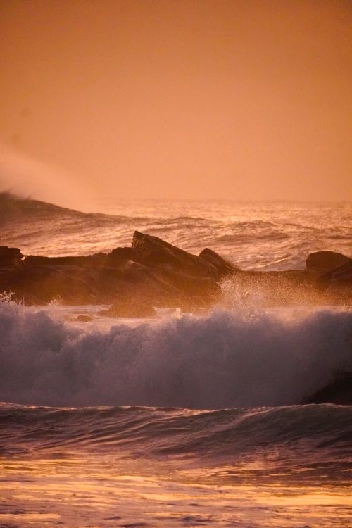 Golden Hour Ocean Waves Crashing on Rocky Shore · Free Stock Photo