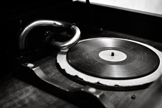 A classic black and white photo of a vintage gramophone and vinyl record highlighting nostalgia and retro music.
