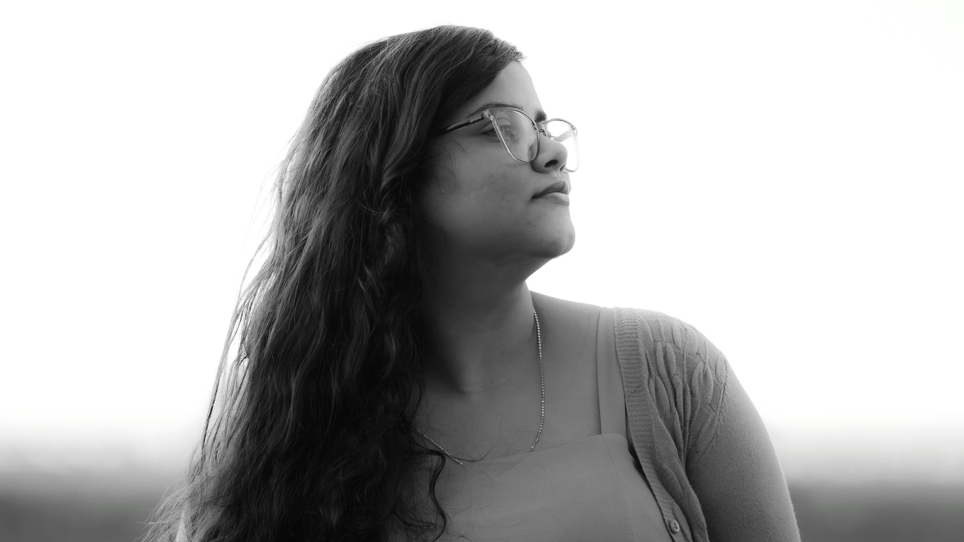 Artistic black and white portrait of a woman looking away, capturing a serene moment.