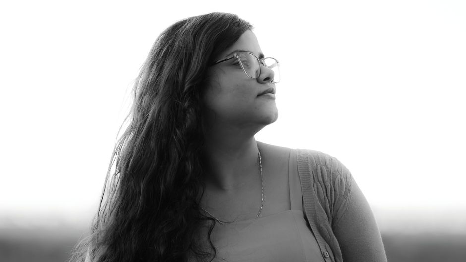 Artistic black and white portrait of a woman looking away, capturing a serene moment.