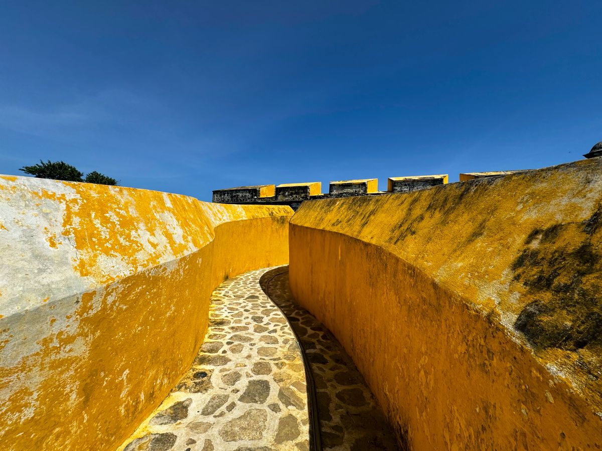 Classic yellow facade with a wooden colonial door in Campeche, Mexico's historic city.