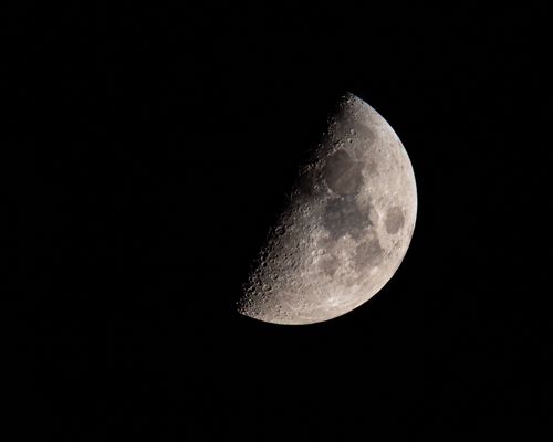 Free Half moon with detailed craters against a dark night sky. Stock Photo