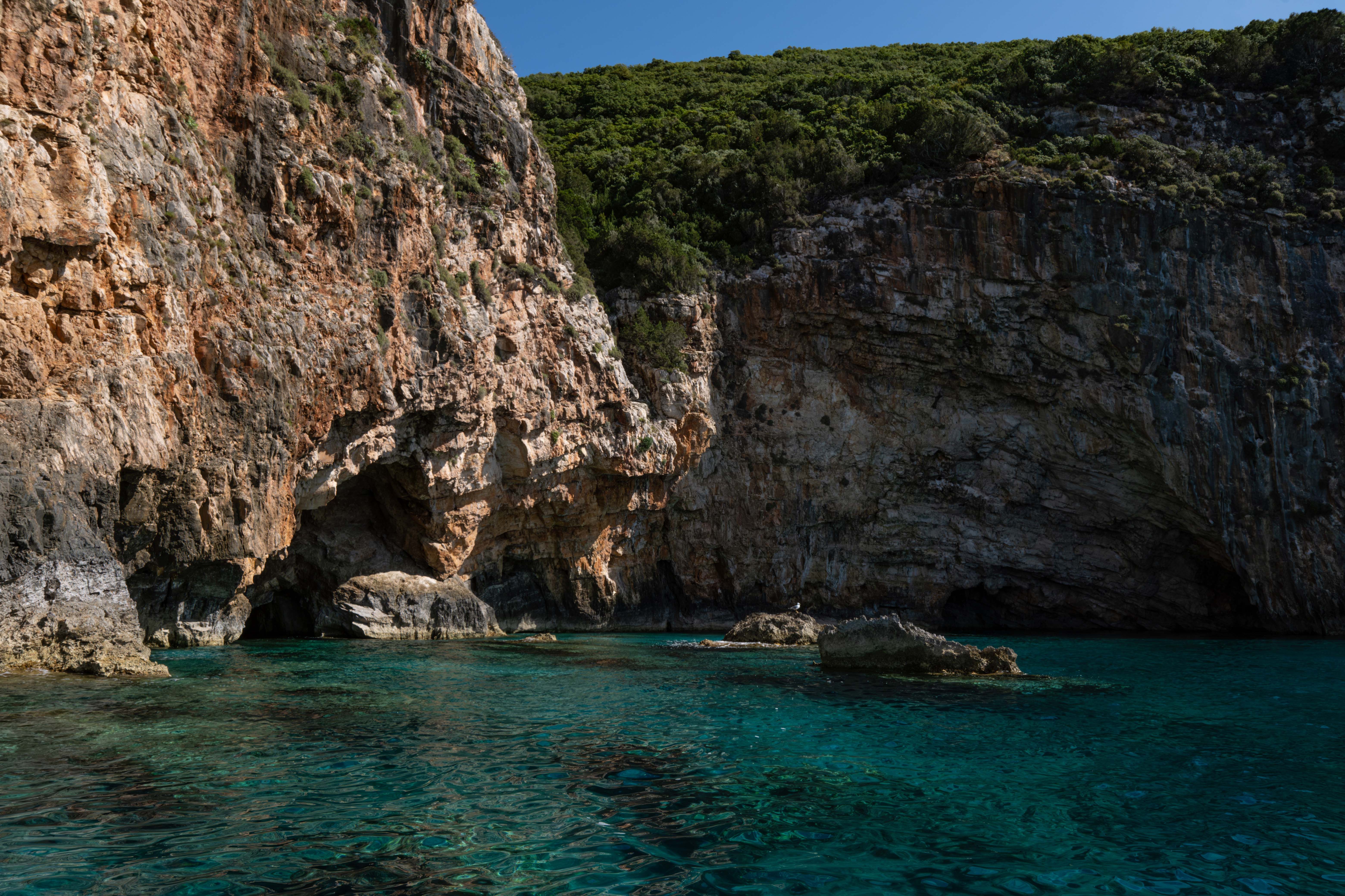 Explore tranquil coastal cliffs with crystal clear blue water, perfect for travel and nature lovers. - Photo by Francesco Ungaro on Pexels