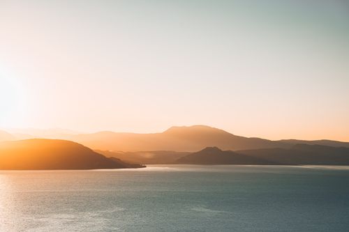 Free Serene view of sunrise over Lake Garda with picturesque mountains in Lombardy, Italy. Stock Photo