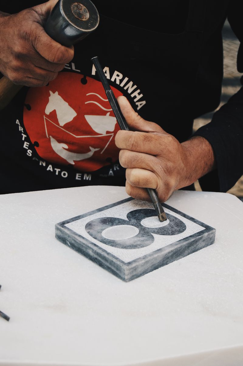 Artisan hands carving stone — the precision of hand work at Stonecraft Atelier