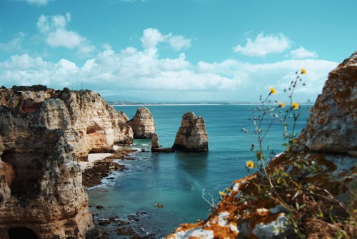 Rock Formation on Sea Under Blue Sky