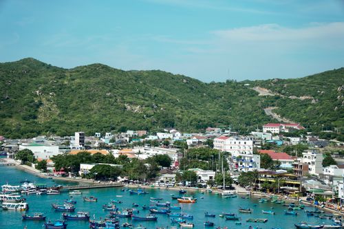 Free A picturesque coastal town view with vibrant fishing boats in a serene bay. Stock Photo