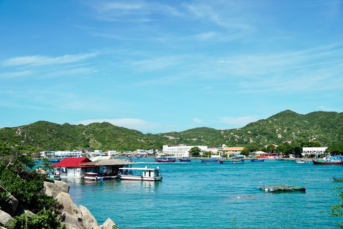 Scenic Coastal Village View with Boats and Hills · Free Stock Photo