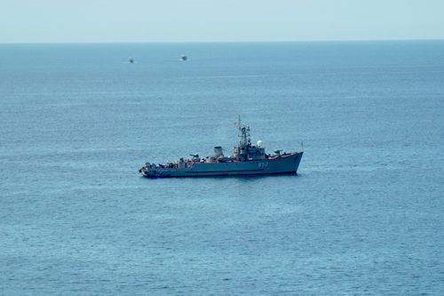 Free A military ship navigating the calm blue ocean under a clear sky, showcasing nautical power. Stock Photo