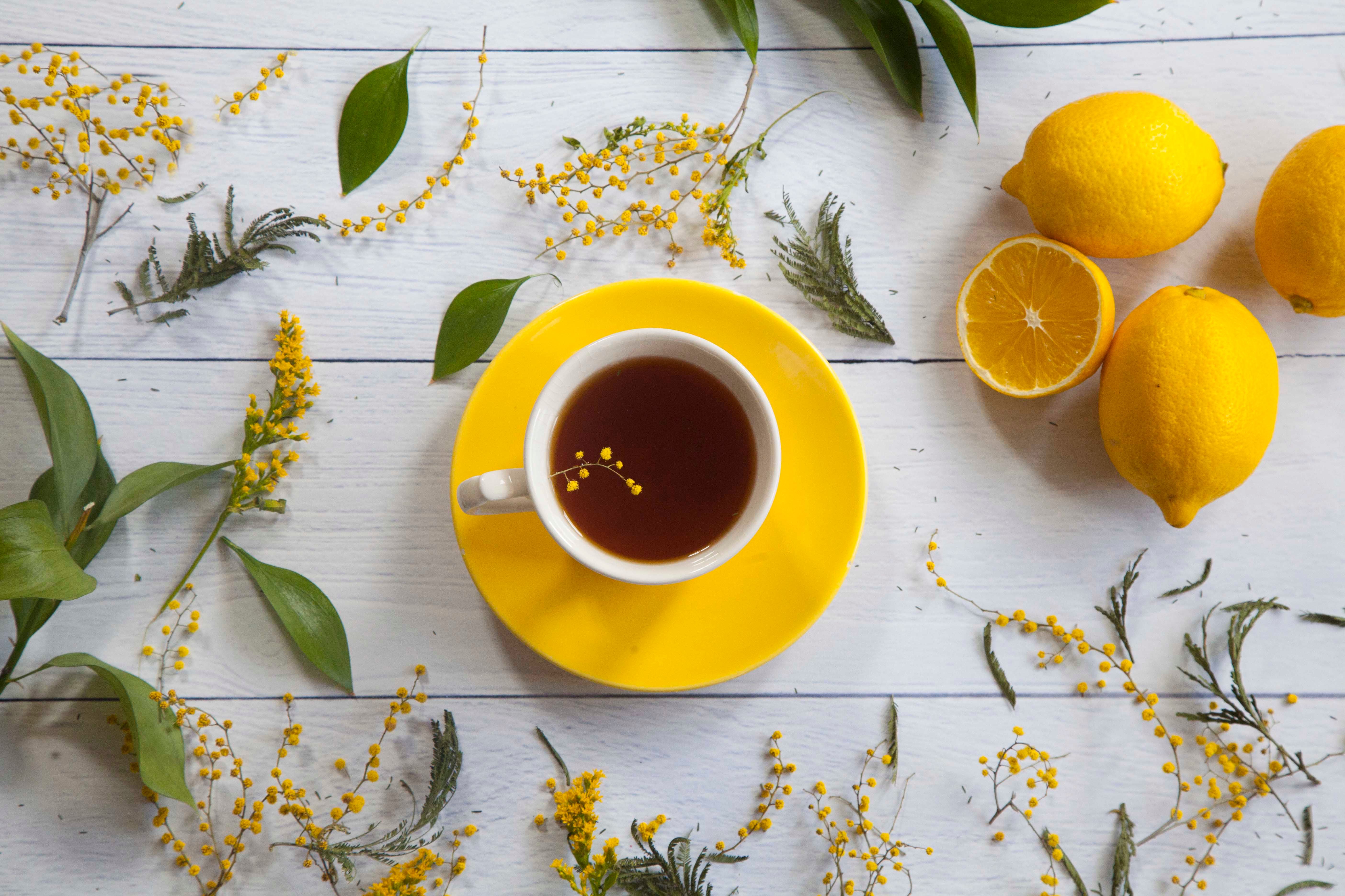 Vibrant Flat Lay of Tea with Lemons and Yellow Flowers · Free Stock Photo