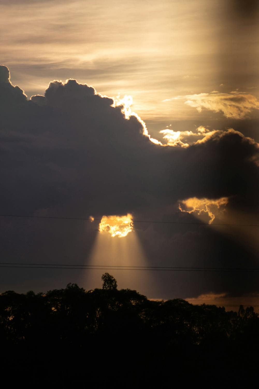 Dramatic Sunset with Sun Rays Behind Clouds · Free Stock Photo