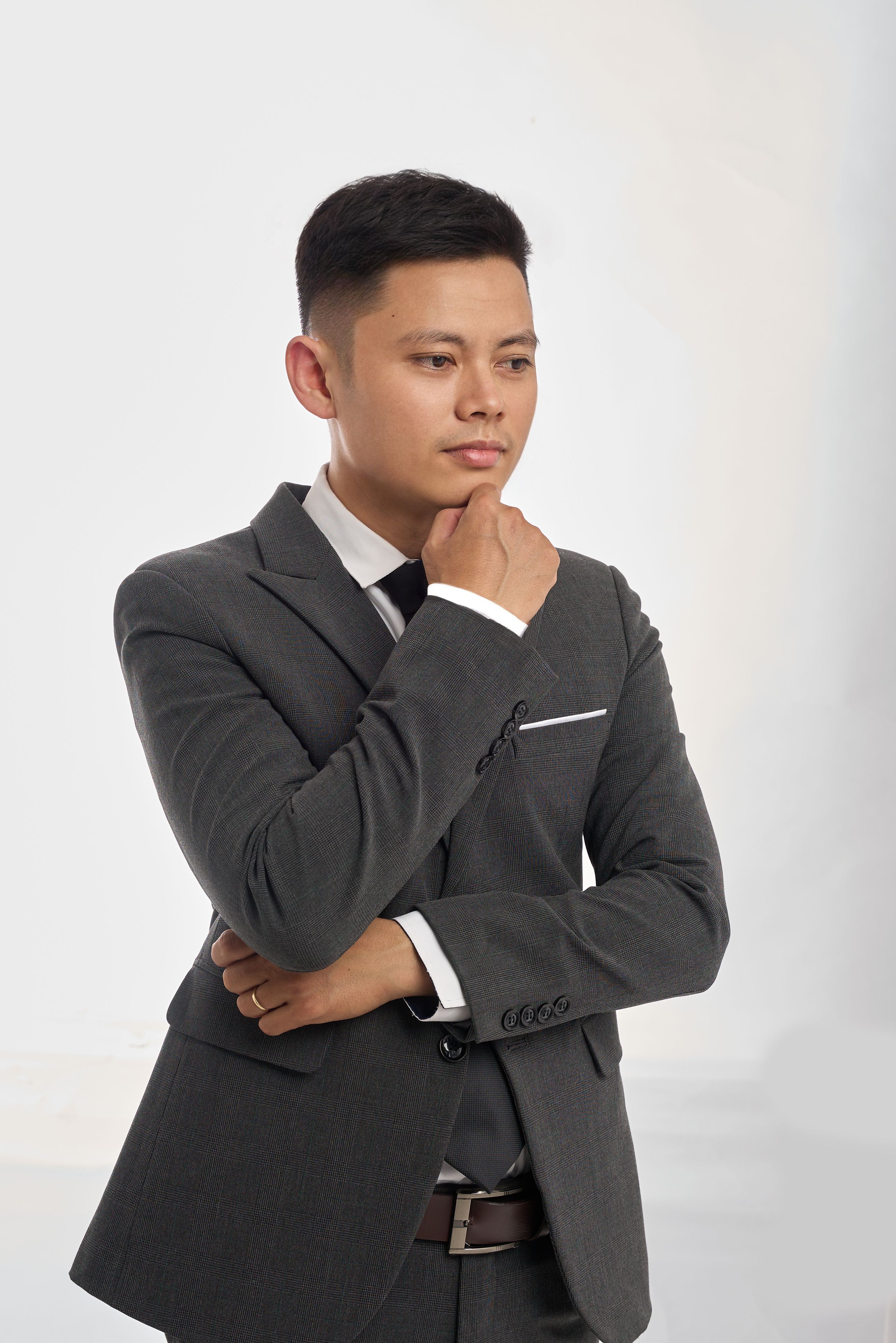 Miễn phí Một người đàn ông mặc vest đang tạo dáng một cách chu đáo trên nền đơn giản. Ảnh lưu trữ