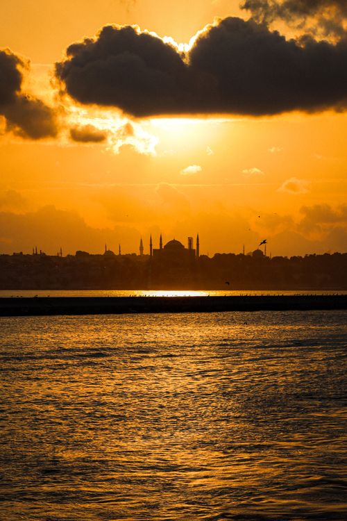 Free Golden sunset view of Istanbul skyline with Hagia Sophia silhouette reflected on Bosphorus waters. Stock Photo