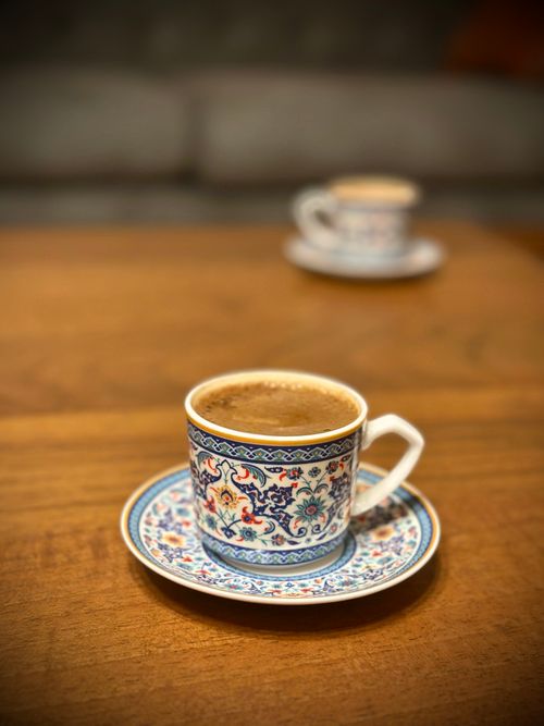 Free Close-up of two intricately designed Turkish coffee cups on a polished wooden table. Stock Photo
