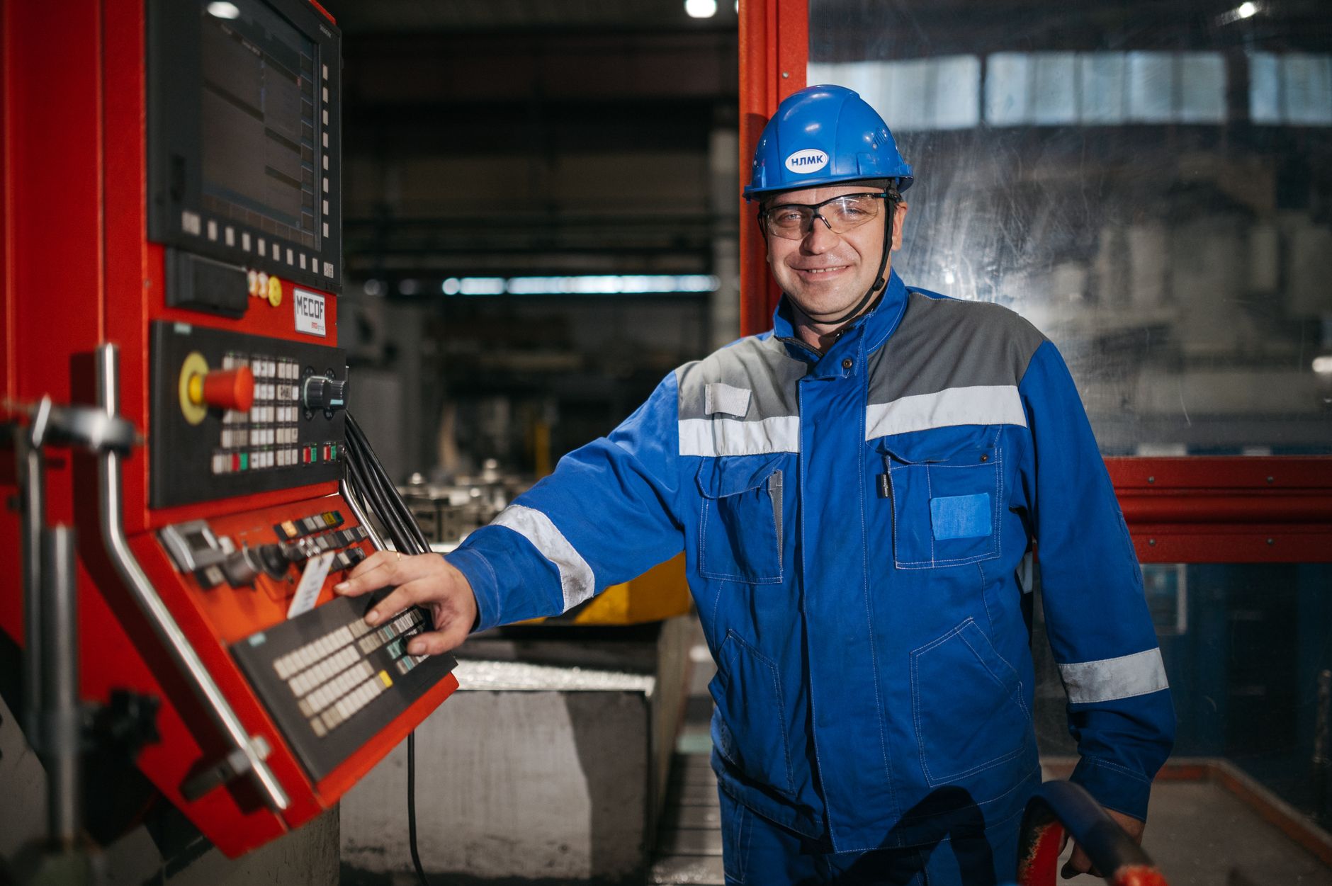 Almanya'da bir metal işleme fabrikasında modern makinelerle çalışan profesyonel bir teknik eleman ve endüstriyel üretim ortamı.