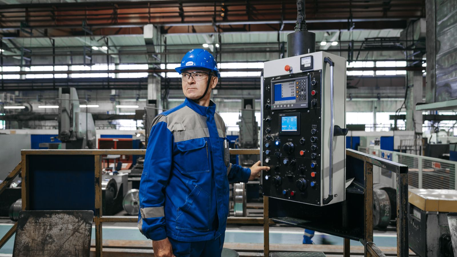 Technicien devant le panneau de commande d’une machine industrielle