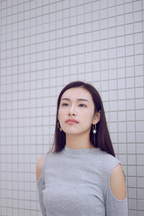 Photo Of Woman Standing Beside White Wall