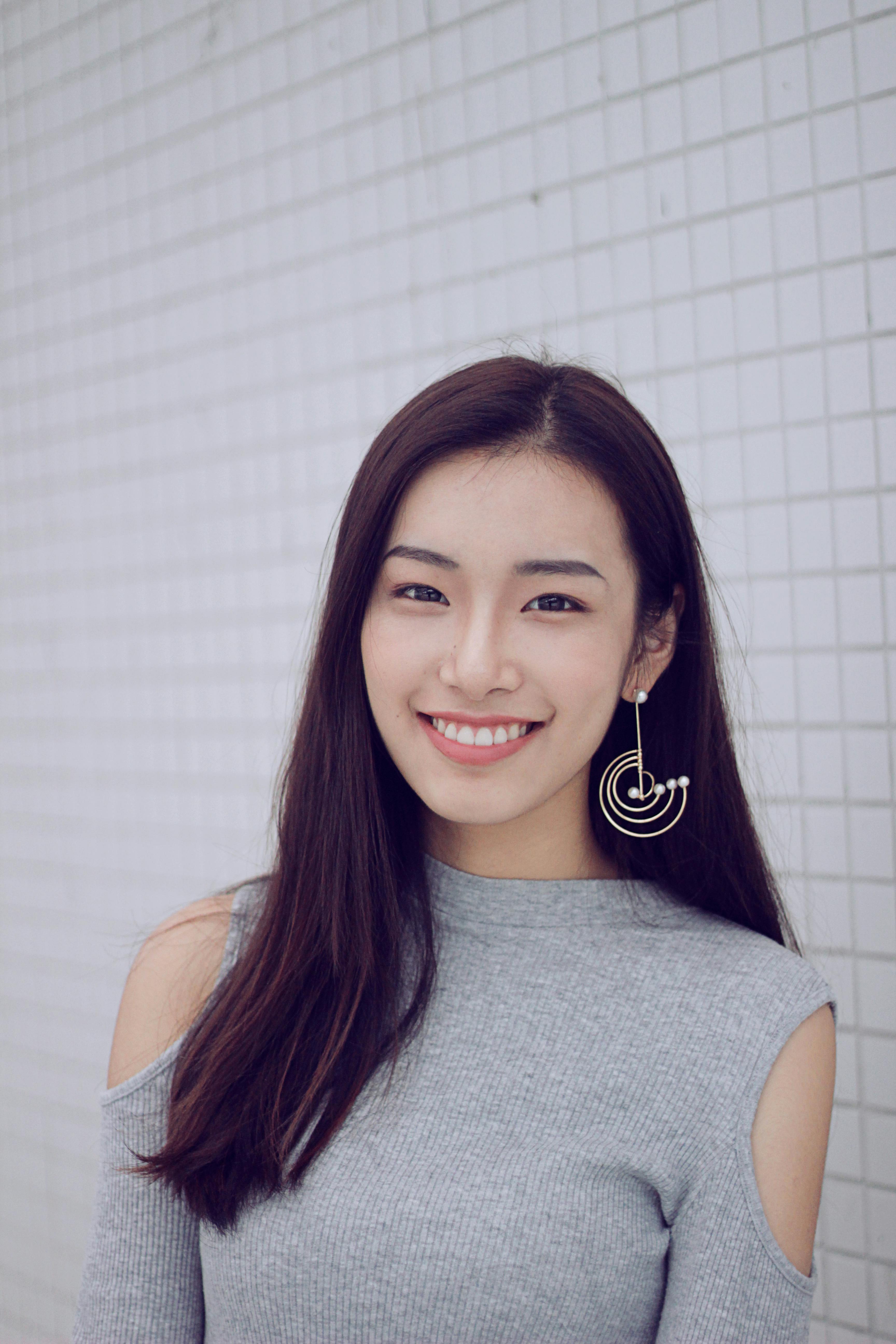 photo of woman standing beside white wall