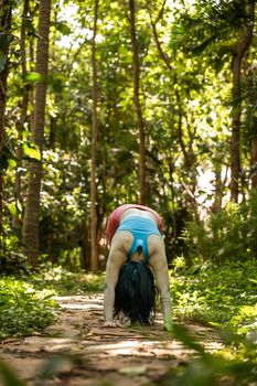 Yoga enthusiast practicing outdoors in a lush, green forest setting.
