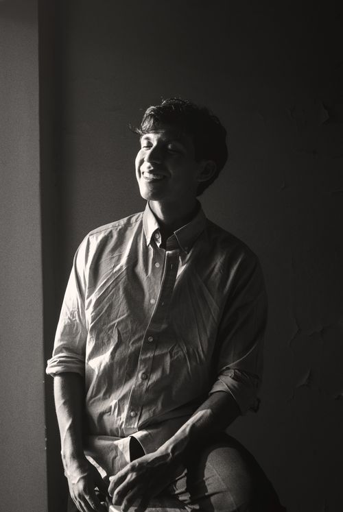 Free Serene black and white portrait of a smiling man in a dimly lit room. Stock Photo