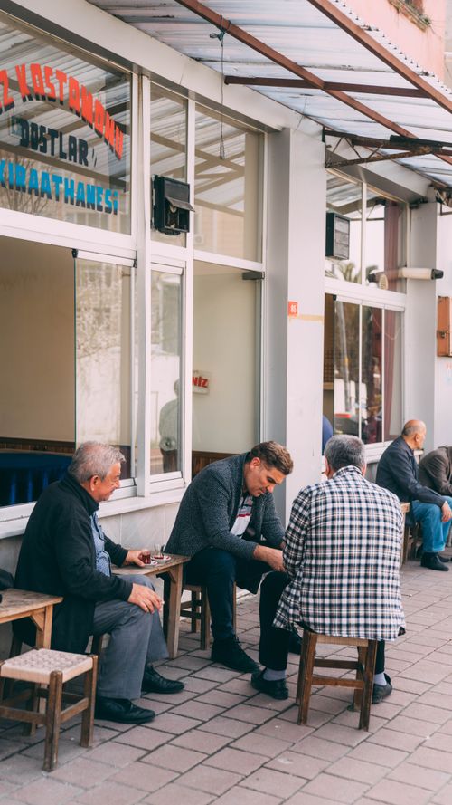 Free Group of men sitting and talking outside a Turkish café during the day. Stock Photo