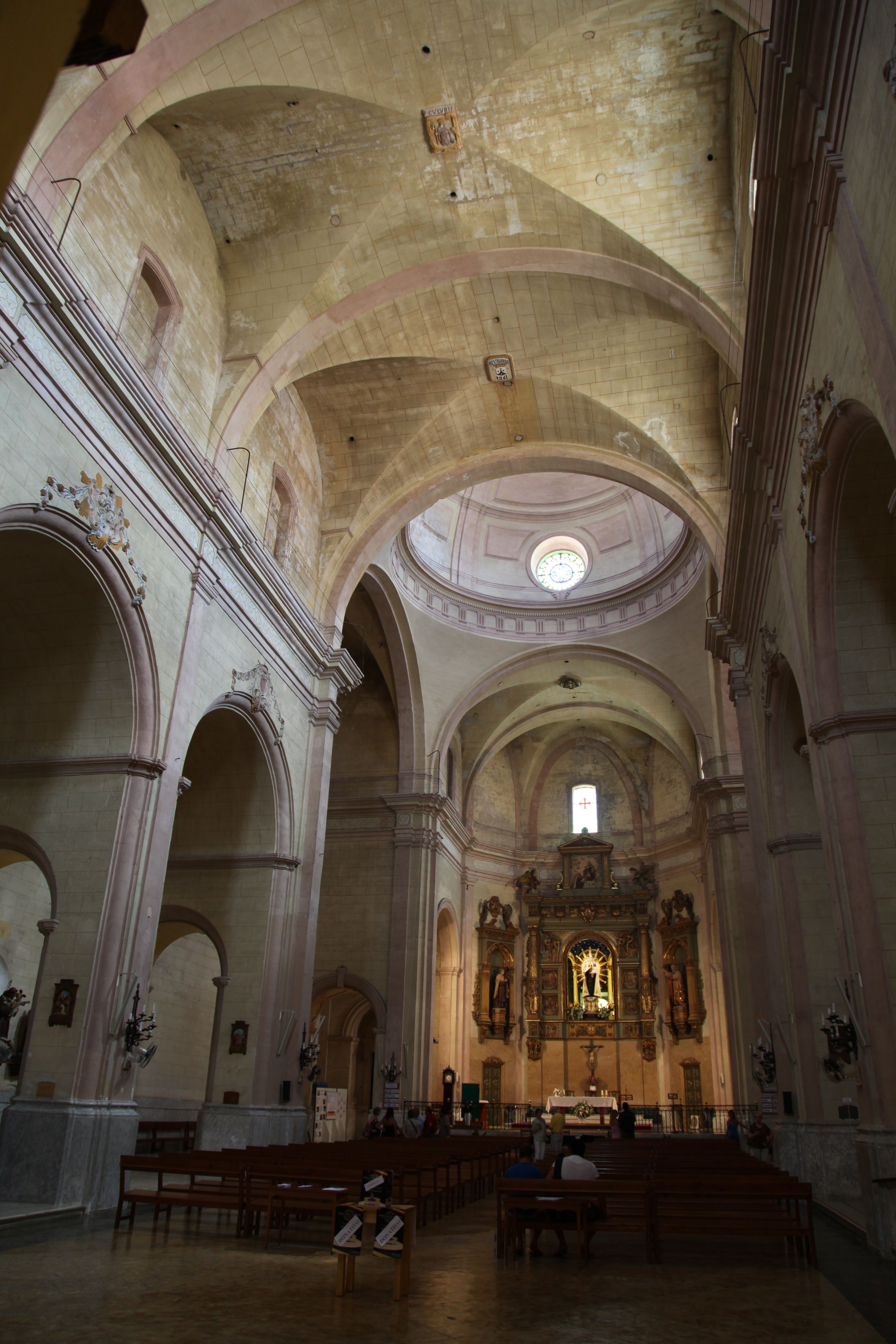 Capture of the grand cathedral interior in Ciudadela de Menorca showcasing majestic arches and ornate altarpiece.