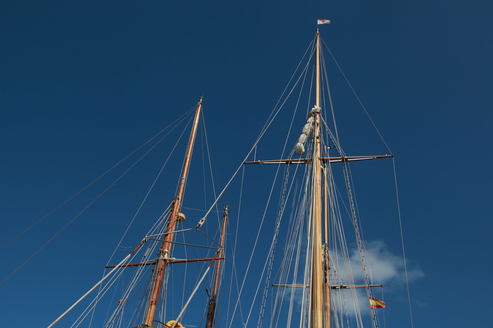 Detailed view of sailboat masts captured against a clear blue sky in Ciudadela de Menorca.