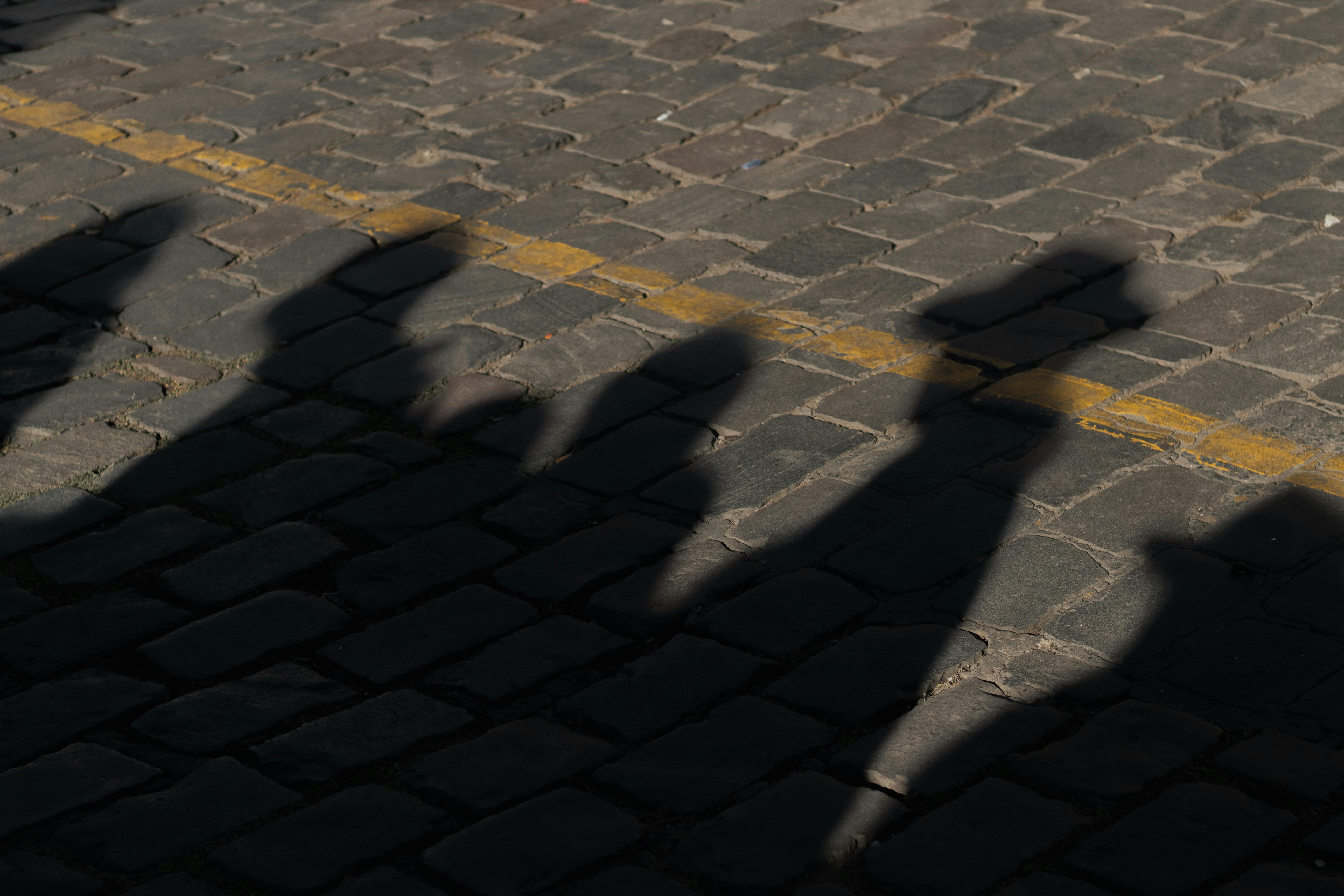 Captivating silhouettes cast on a cobblestone street in Cusco, Peru.