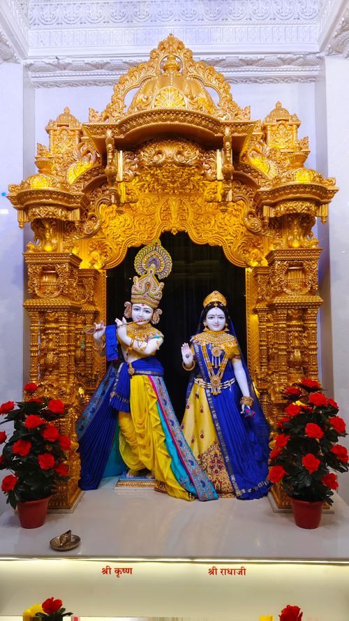 Free Vibrant Hindu deity statues in a richly decorated shrine with gold embellishments and colorful attire. Stock Photo