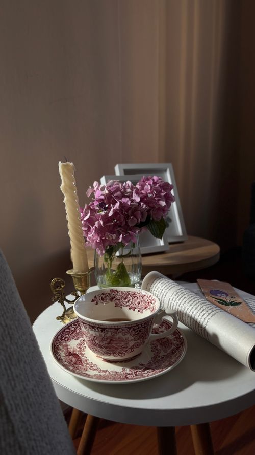 Free Cozy morning setup with a vintage tea set, hydrangeas, and a newspaper on a round table. Stock Photo