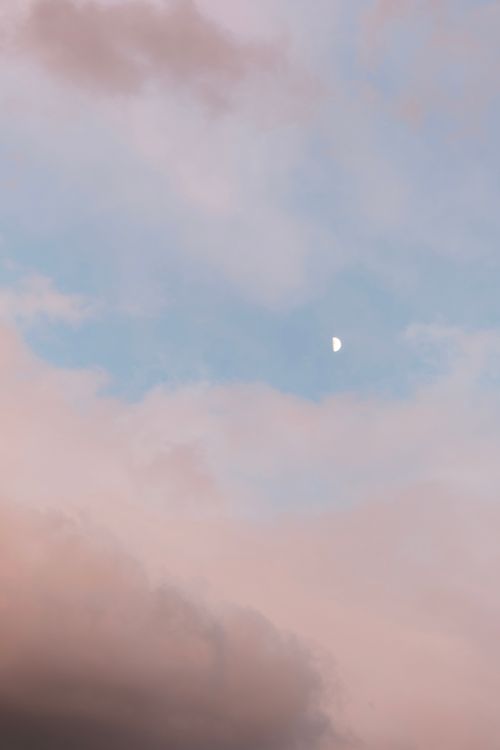 Free Serene sky with pastel clouds and a half moon at twilight. Stock Photo