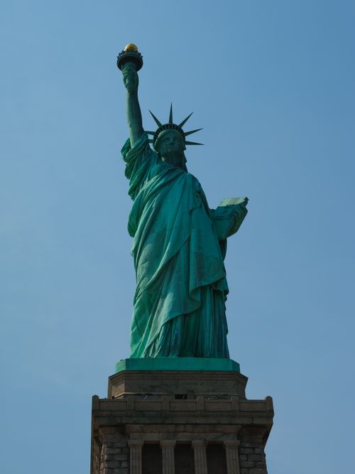Free Iconic Statue of Liberty with clear blue sky, symbolizing freedom and hope in New York City. Stock Photo