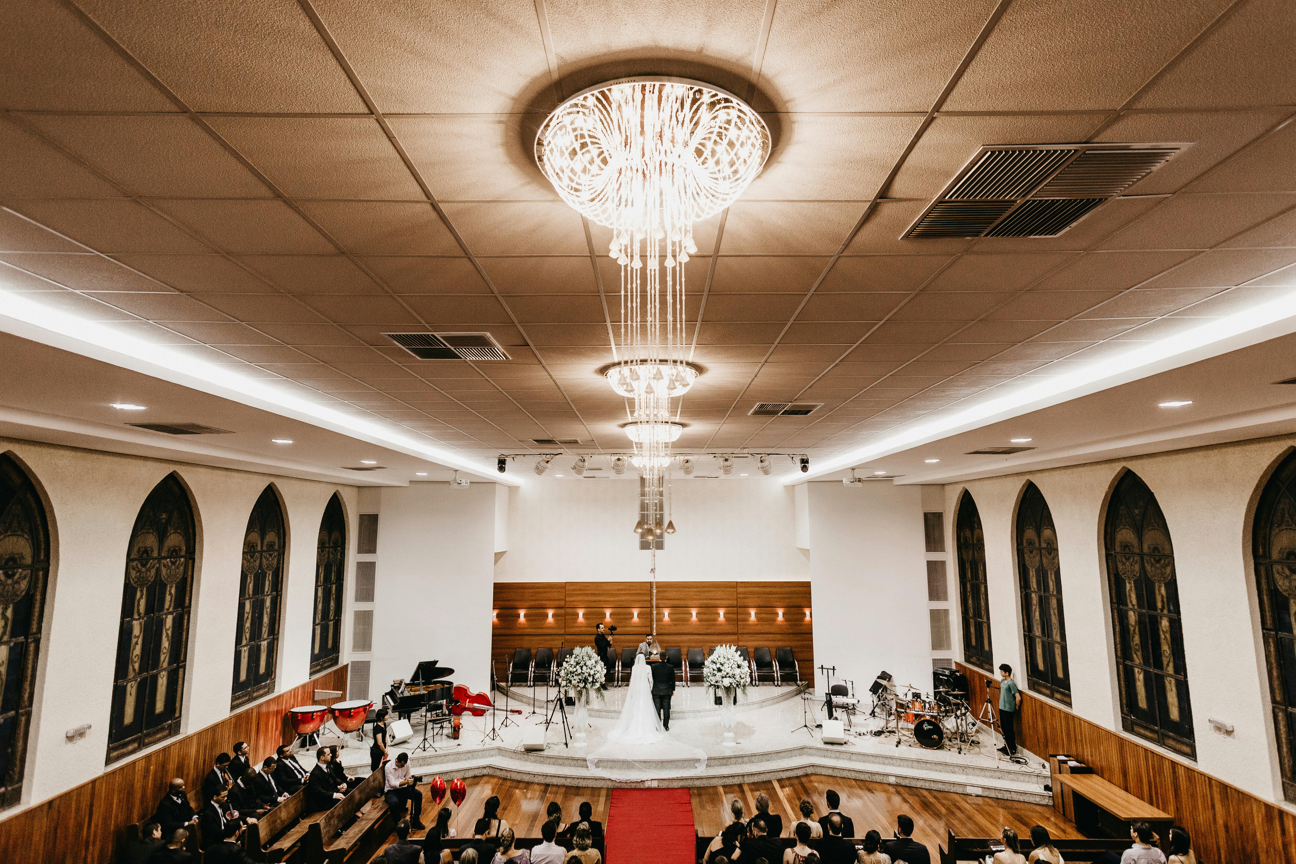 一场配有令人惊叹的枝形吊灯的室内婚礼，宾客就座，尽显奢华与优雅