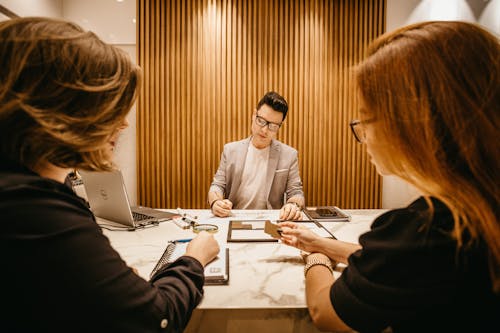 兩個女人坐在桌子旁邊的男人