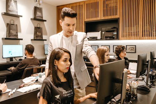 Free Man Teaching Woman in Front of Monitor Stock Photo